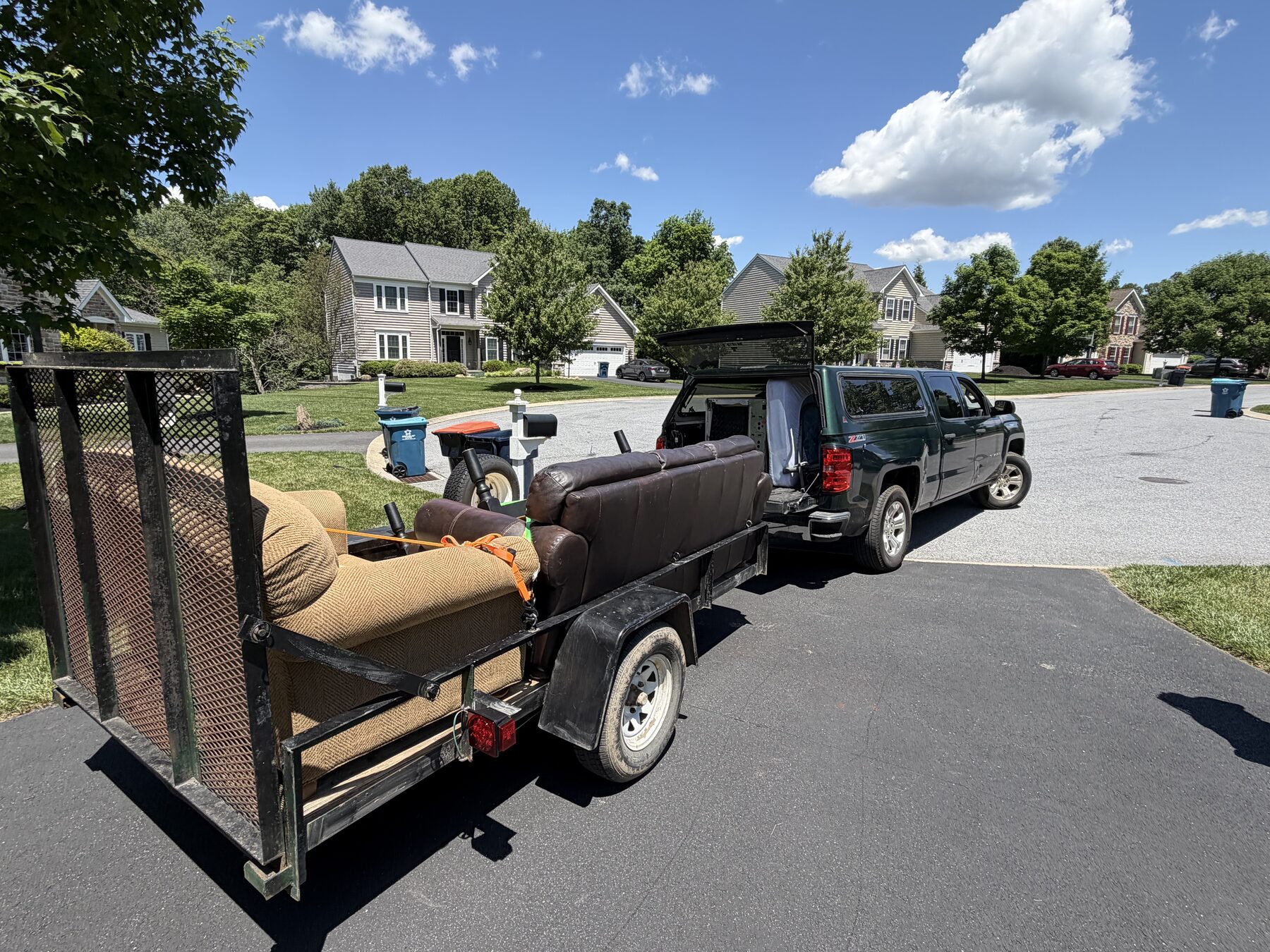 Trailer loaded with a full living room set, hitched to the Miller's Pickup Services truck